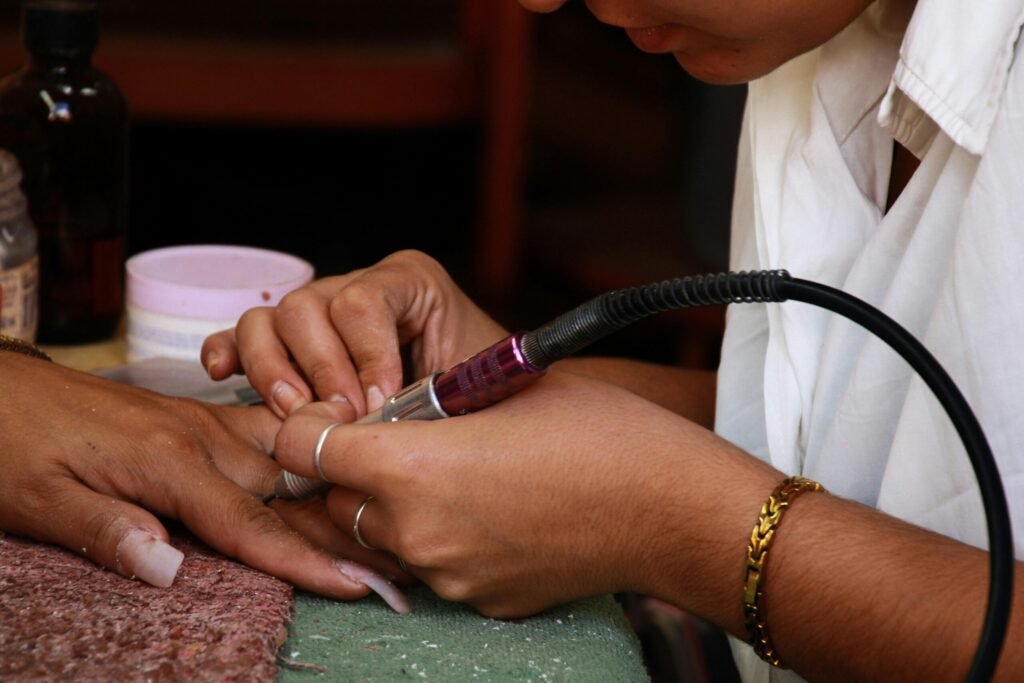 Close-up of a professional manicure service highlighting precise nail work in a salon setting.