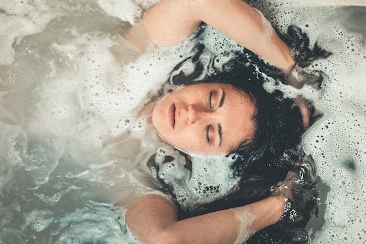 Calm and serene young woman enjoying a bubble bath with her eyes closed. shampoo