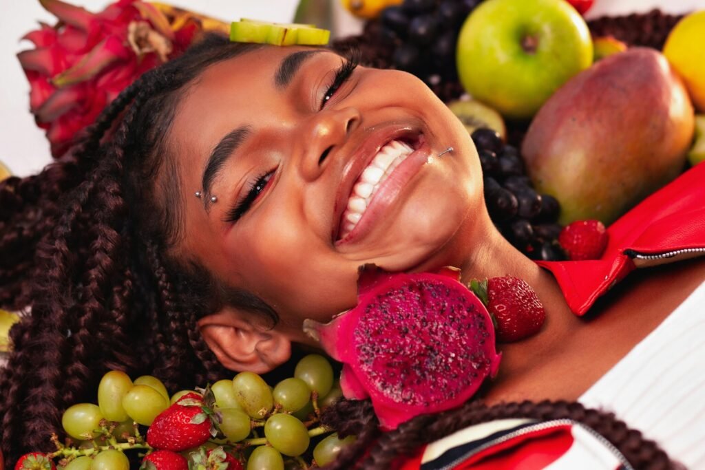 Joyful girl surrounded by vibrant tropical fruits in Brazil, showcasing natural beauty and happiness.