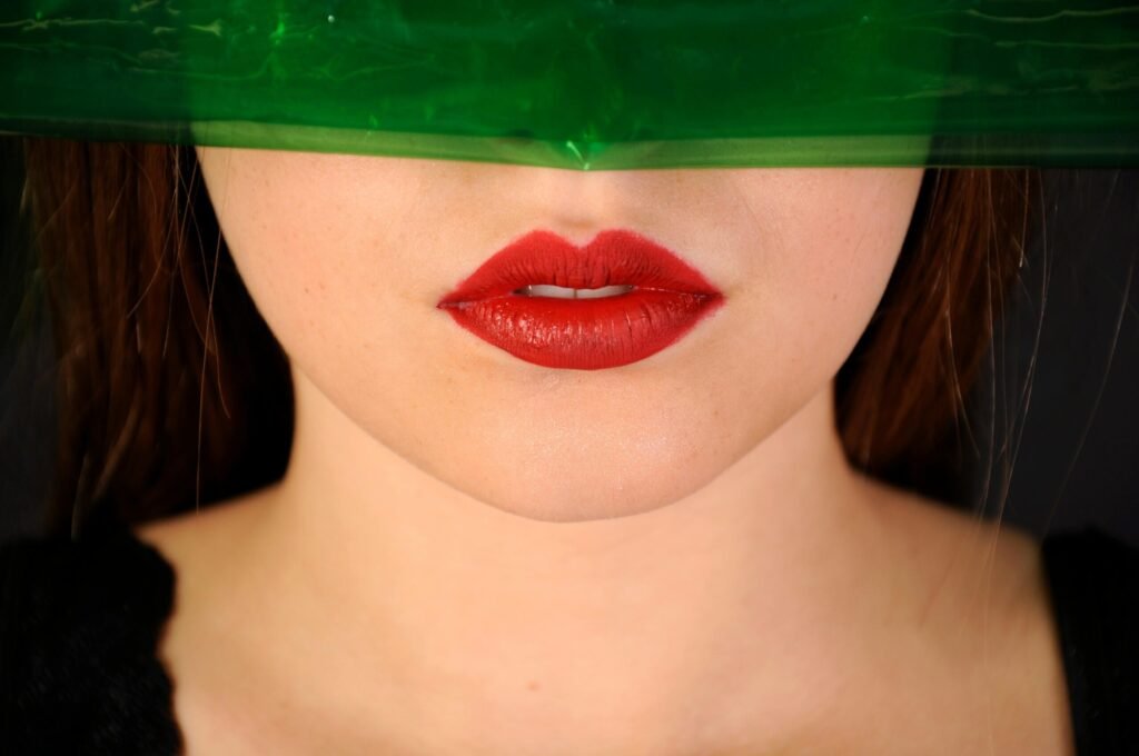 Artistic close-up photo of red lips with a green overlay, creating a vibrant and modern look.