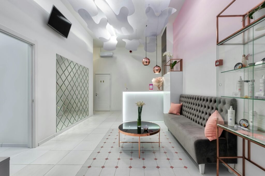 Interior of contemporary reception hall with sofa and glass table with TV set hanging on wall in beauty salon