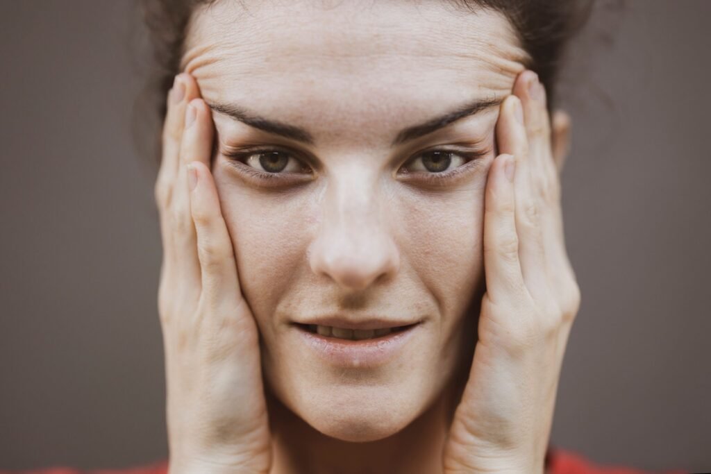 Detailed close-up portrait of a woman gently holding her face, conveying a thoughtful expression.